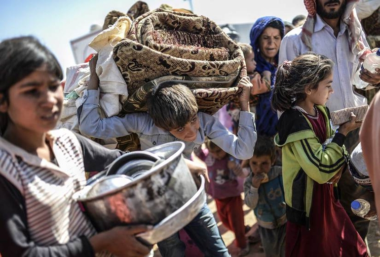 fot. Bulent Kilic / AFP / Getty Images / 23 września 2014
Syryjscy Kurdowie przenoszą swój dobytek przez granice turecką
